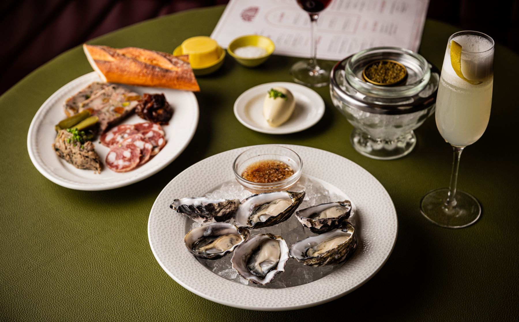 Oysters, charcuterie, baguette and drinks on a Parlour table